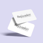 Two white gift cards with the Rejûvaskin brand logo printed on them, placed against a purple background.